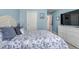 Serene bedroom featuring a bed with a patterned duvet, a dresser, and light blue walls at 4013 S Carson St # C, Aurora, CO 80014