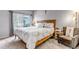 Comfortable bedroom with a large window, wood bed frame and neutral decor at 4013 S Carson St # C, Aurora, CO 80014