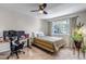 Cozy bedroom featuring a bed with a striped blanket, work space, ceiling fan, and natural lighting at 4013 S Carson St # C, Aurora, CO 80014