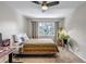 Inviting bedroom showcasing a bed with a striped blanket, ceiling fan, work space, and ample natural light at 4013 S Carson St # C, Aurora, CO 80014