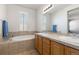 Bright bathroom with double sinks, lots of lights, and a large tub creating a spa-like feel at 3454 Cascina Pl # D, Highlands Ranch, CO 80126