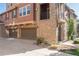 Exterior view features a stucco and stone facade, plus two-car garage and landscaped front yard at 3454 Cascina Pl # D, Highlands Ranch, CO 80126