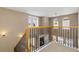 Hallway with view of a staircase, windows and railing showcasing the home's architectural design at 3454 Cascina Pl # D, Highlands Ranch, CO 80126