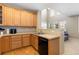 Eat-in kitchen featuring a breakfast bar, wood cabinets, and a double sink at 3454 Cascina Pl # D, Highlands Ranch, CO 80126