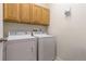 Functional laundry room features a washer, dryer, and built-in overhead cabinets for storage at 3454 Cascina Pl # D, Highlands Ranch, CO 80126