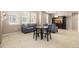 Open living room area featuring neutral carpeting, gray sofas, and large windows at 3454 Cascina Pl # D, Highlands Ranch, CO 80126