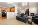 Open living room floor plan with adjacent kitchen, fireplace, staircase, and neutral carpet at 3454 Cascina Pl # D, Highlands Ranch, CO 80126