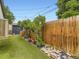 Backyard with artificial turf, wooden fence, rock landscaping, and greenery at 2260 Leyden St, Denver, CO 80207