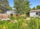 Lush backyard featuring a patio, attractive plantings, and mature trees at 2260 Leyden St, Denver, CO 80207