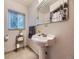 Charming bathroom featuring a pedestal sink, decorative mirror, and classic fixtures at 2260 Leyden St, Denver, CO 80207