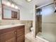 Modern bathroom featuring tiled walls, vanity with sink, large mirror, and glass enclosed shower at 2260 Leyden St, Denver, CO 80207