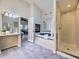 Bright main bathroom featuring a soaking tub, tiled shower, and a separate vanity area at 2260 Leyden St, Denver, CO 80207