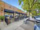 Bistro Vendome building with outdoor patio seating and shade, surrounded by lush trees at 2260 Leyden St, Denver, CO 80207
