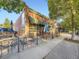 An exterior shot of a brick retail building with awning and outdoor seating area at 2260 Leyden St, Denver, CO 80207