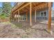 Outdoor backyard with patio, seating, under-deck beams, landscaped yard, and budding tulips at 1312 Pine View Rd, Golden, CO 80403