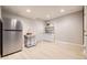 Finished basement with a refrigerator, kitchenette, light wood floors, and a painted gray color scheme at 1312 Pine View Rd, Golden, CO 80403