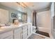 Bright bathroom featuring double sinks, a large mirror, and a shower-tub combo at 1312 Pine View Rd, Golden, CO 80403