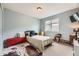 Comfortable bedroom with light blue walls, a cozy bed, a window, and charming decor at 1312 Pine View Rd, Golden, CO 80403