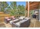 Inviting outdoor deck with wicker seating, cushions, and a view surrounded by lush trees at 1312 Pine View Rd, Golden, CO 80403
