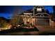 Charming two-story home with a stone facade, manicured lawn, and a two-car garage at twilight at 1312 Pine View Rd, Golden, CO 80403
