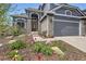 Charming home featuring a stone facade, arched entryway, and vibrant landscaping at 1312 Pine View Rd, Golden, CO 80403