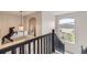 Elegant foyer showcasing staircase with black railings, a statement light fixture and arched window at 1312 Pine View Rd, Golden, CO 80403