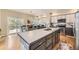 Modern kitchen with a large island, stainless steel appliances, and an adjacent dining area at 1312 Pine View Rd, Golden, CO 80403