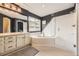 Dark-walled bathroom with a white vanity, soaking tub, and glass-enclosed shower at 1312 Pine View Rd, Golden, CO 80403