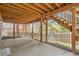 Under-deck patio with bare concrete, wooden support beams, landscaped yard, and houses in view at 1312 Pine View Rd, Golden, CO 80403