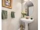 Bright powder room with a pedestal sink, oval mirror, and decorative accents at 1312 Pine View Rd, Golden, CO 80403