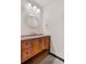 A charming powder room with a wood vanity, stone countertop, and chrome fixtures provides ample space at 1456 S Jasper St, Aurora, CO 80017