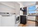 Convenient laundry room with modern appliances and ample natural light from the window at 1456 S Jasper St, Aurora, CO 80017