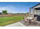 This home features a patio with a dining table, seating set and a well-maintained lawn at 17276 E 103Rd Ave, Commerce City, CO 80022