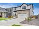 Charming two-story home features a stone facade, white siding, and a spacious two-car garage at 17276 E 103Rd Ave, Commerce City, CO 80022