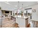 Bright, open-concept space with a modern kitchen island, stainless appliances, and seamless flow to dining and living areas at 17276 E 103Rd Ave, Commerce City, CO 80022