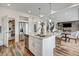 Open concept kitchen, dining, and living space with white cabinets, stainless appliances, and modern design at 17276 E 103Rd Ave, Commerce City, CO 80022