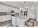 Modern kitchen featuring white cabinets, stainless steel appliances, an island with seating and ample natural light at 17276 E 103Rd Ave, Commerce City, CO 80022