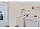 Functional laundry room with white washer and dryer, and storage shelving at 17276 E 103Rd Ave, Commerce City, CO 80022