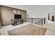Neutral-toned loft featuring a cozy rug, fireplace, and a modern entertainment center at 17276 E 103Rd Ave, Commerce City, CO 80022