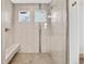 Modern walk-in shower with sleek tilework, a built-in bench, and glass enclosure at 17276 E 103Rd Ave, Commerce City, CO 80022