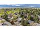 Aerial neighborhood view with mature trees, lush lawns, and mountain views in the distance on a partly cloudy day at 7126 Cedarwood Cir, Boulder, CO 80301