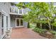Charming backyard with a brick patio, lush greenery, string lights and lovely back porch with white trim at 7126 Cedarwood Cir, Boulder, CO 80301