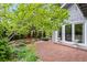 Charming backyard area with brick patio, lush greenery, and mature trees at 7126 Cedarwood Cir, Boulder, CO 80301