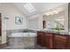 A relaxing bathroom with a soaking tub, skylight, and wooden cabinets at 7126 Cedarwood Cir, Boulder, CO 80301