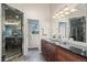A spacious bathroom featuring dual sinks, dark wood cabinets, granite countertops, and glass enclosed shower at 7126 Cedarwood Cir, Boulder, CO 80301