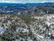 Aerial view of a snowy mountain community with scattered houses at 11498 Pauls Ln, Conifer, CO 80433