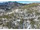 Aerial view of a winding mountain road and snowy landscape at 11498 Pauls Ln, Conifer, CO 80433