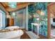 Elegant bathroom featuring a statement wall, soaking tub and double vanity at 11498 Pauls Ln, Conifer, CO 80433