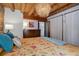 Primary bedroom with a large bed, dresser and wood-paneled walls at 11498 Pauls Ln, Conifer, CO 80433