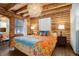 Cozy bedroom with a large bed, wood-paneled walls and a unique chandelier at 11498 Pauls Ln, Conifer, CO 80433